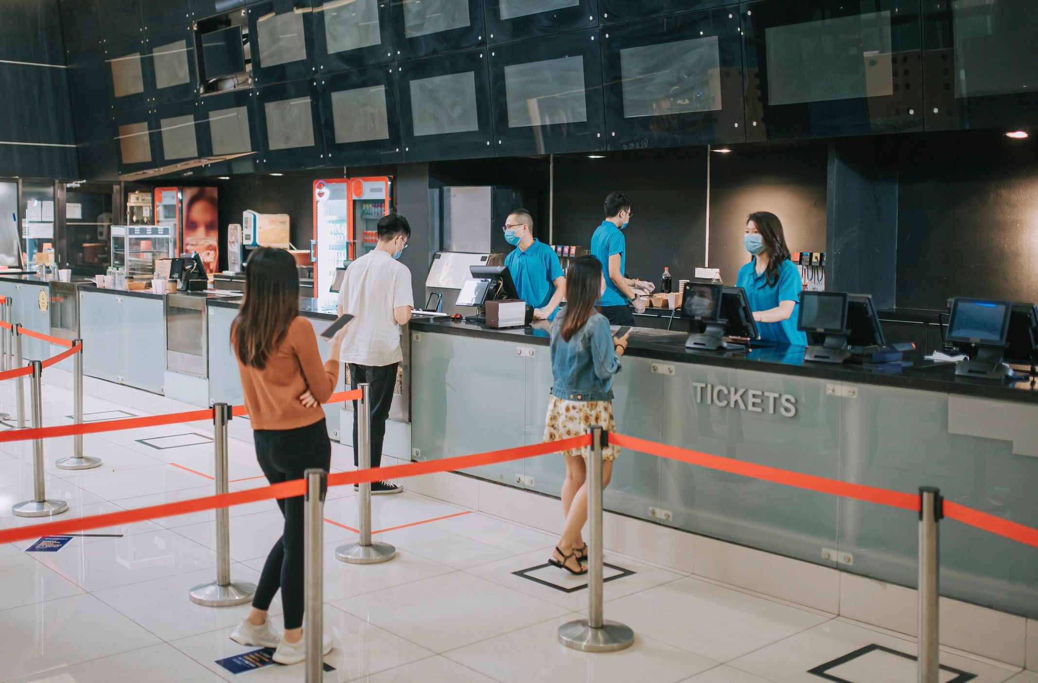 Audience at a movie theater buying tickets and refreshments