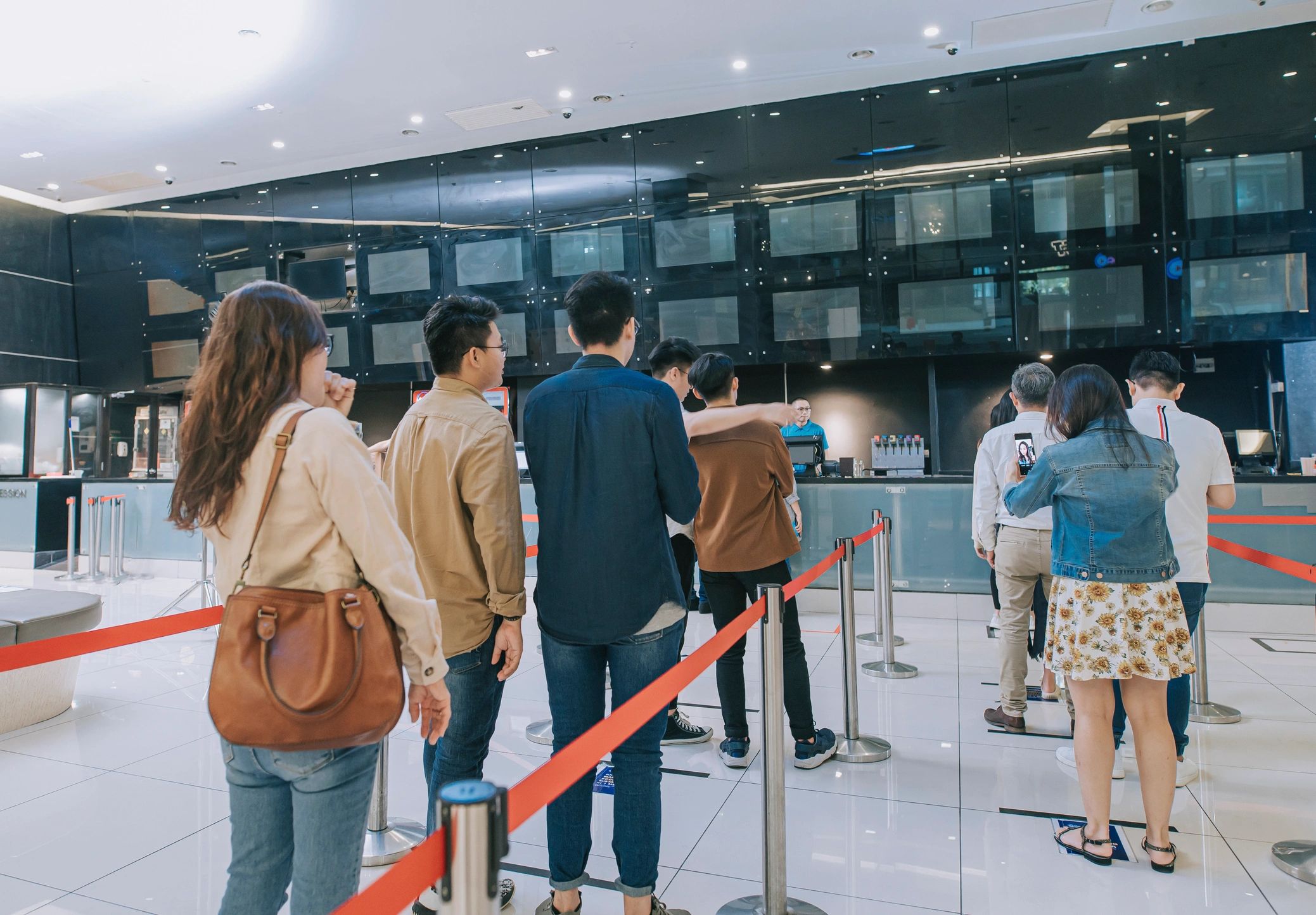 Movie theater audience lining up at a cinema concession and ticket area